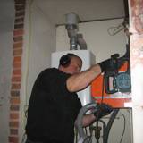 Man boort gaten in de muur met apparatuur.