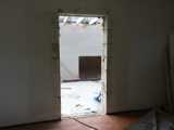 Deuropening in aanbouw met zichtbare houten of betonnen constructie.